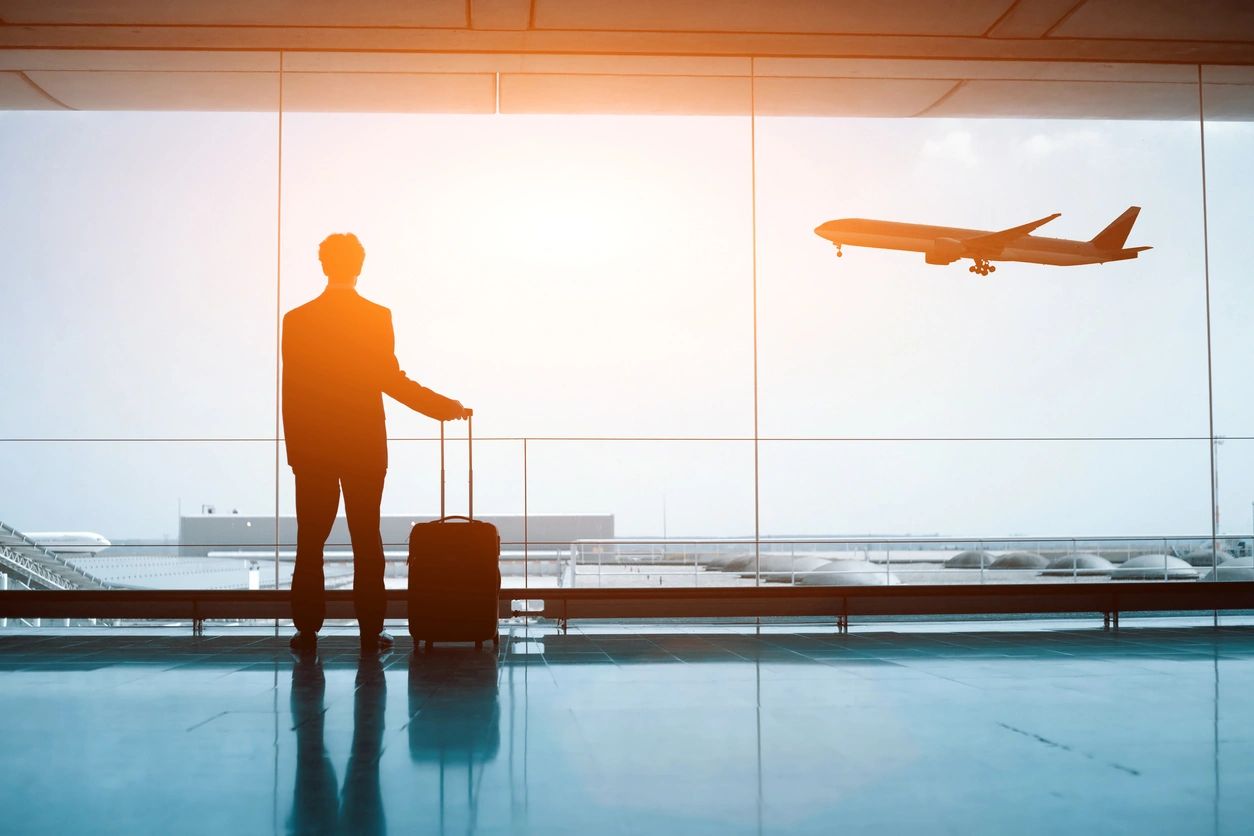 Man waiting at airport while plane takes off